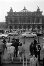 Fußgänger betreten und verlassen die Metrostation an der Pariser Oper, 1962. Pedestrians entering and leaving the metro station at the Paris Opera, 1962.