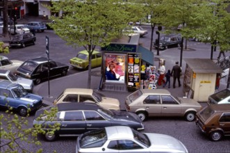 Street scene with news kiosk and traffic in Paris, France circa 1979.
