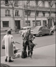 Paris 1965 reportage moment lifestyle fashion street reportage. Citroen Deaux Chevaux passing in background Van de Poll [Street life in Paris] Man playing and feeding the dog of a passer-by 1965  Fran...