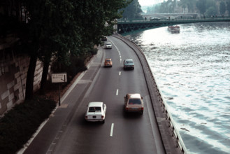 Sparse traffic on the road alongside the Seine river in Paris during the 1970s