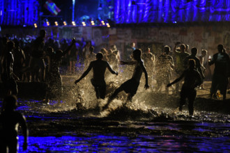 People having fun in the mud pool of the Przystanek Woodstock Music festival in Kostrzyn, Poland.