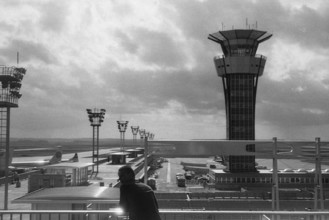 A historical photograph of Orly Airport in Paris, taken in 1965. The image captures the modern architecture of the airport during the mid-20th century, reflecting the period's aviation advancements.