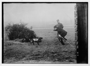 This image captures a Red Cross dog in Vincennes, France, summoning help for a wounded man. The photograph highlights the vital role of animals in wartime rescue efforts and humanitarian aid.