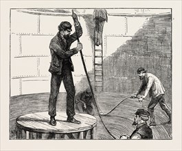 MANUFACTURING AN ELECTRIC TELEGRAPH CABLE: COILING DOWN THE CABLE IN THE TANK, 1873