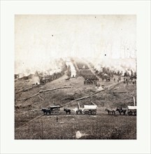 American Civil War: Three horse-drawn covered wagons in the foreground. Soldiers marching in