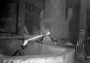 Eddystone, Pennsylvania - Railroad parts. Baldwin Locomotive Works. Moulder takes a small pot of