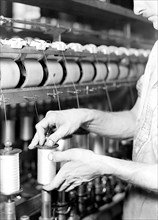 Paterson, New Jersey - Textiles. Rayon yarn being wound from one bobbin on to another and being
