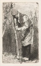 Man binds beans stakes in vegetable garden, print maker: Bernardus Johannes Blommers, 1855 - 1914