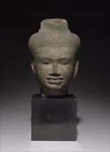 Head of a Follower of Shiva, 900s. Cambodia, Angkor, 10th century. Sandstone; overall: 25 x 18 x 16