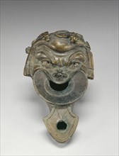 Lamp in the Shape of a Comic Mask; Roman Empire; 75 - 125; Bronze; 6.9 × 12.5 cm, 2 11,16 × 4 15,16 in
