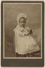 baby wearing a bonnet, holding a flower, seated; Smith, American, active Burlington, Iowa 1870s, about 1890; Albumen silver