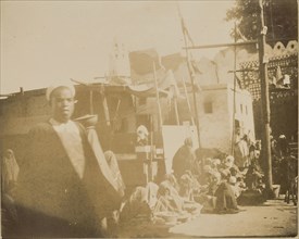 Group of people sitting on ground in a row; about 1860 - 1880; Tinted Albumen silver print