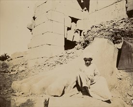 Young man sitting at base of sculptural ruins; Egypt; about 1860 - 1880; Tinted Albumen silver print