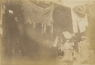 Figures in front of booth; about 1860 - 1880; Tinted Albumen silver print