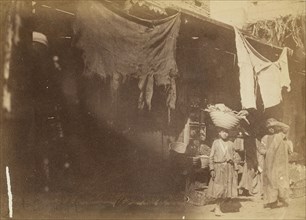 Figures in front of booth; about 1860 - 1880; Tinted Albumen silver print