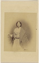 woman with checkered shawl, standing; about 1865; Albumen silver print