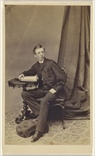 young man seated at a table with a book on top; A. Melliss, British, active Liverpool, England 1860s, 1860s; Albumen silver