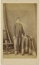 young man posed at table with books and cap, standing; C. Hart, British, active Exeter, England 1860s, 1870s; Albumen silver
