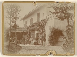 Group of people with two dogs at front of house, some seated; 1885 - 1899; Gelatin silver print