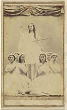 Female group portrait, six in white gowns kneeling, one standing holding a cross; about 1865; Albumen silver print