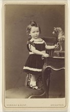 Gerard Carter. March 1875. Aged 20 months,Little child standing on a chair, holding a carved horse on a table; Hennah & Kent