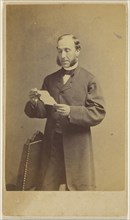 Man with muttonchops reading a letter, standing; J.A. Whipple, American, 1822 - 1891, about 1865; Albumen silver print