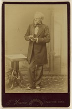 A Game of Cards, actor holding playing cards, standing; Theophile W.M. Havee, American, 1848 - 1921, active Stamford