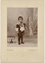 Little boy standing, holding an American flag; MacIntire, American, active 1890s, about 1890; Gelatin silver print
