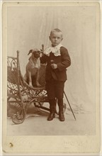Little boy standing, holding a cane, with a little dog in a wicker chair; G. Wick, American, active Norwich, New York 1870s