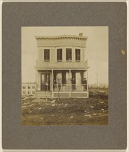 View of a Victorian-style house with five people on the front porch; 1890s; Gelatin silver print