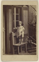 Genrebilder nach der Natur. Landliche Unschuld.  little girl with scarf on head, standing in a chair; German; about 1862