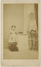 little girl, standing on covered box; 1870 - 1875; Albumen silver print