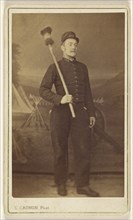 man in uniform standing, with what is possibly a cannon sponge over his shoulder; E. Cagon, French, active Argentina 1860s