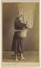 Peasant woman standing, holding a basket with a long pole and net; Louis De Mauny, French, active 1860s, 1865 - 1870; Albumen