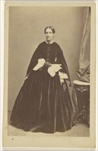 woman wearing a long dark dress, holding a kerchief, standing; Bendann Brothers, American, active 1850s - 1873, 1859 - 1862