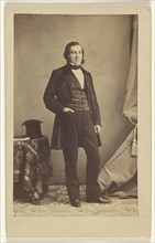 man with muttonchops, standing with his right hand in pocket, top hat on table; Bailly & Maurice; 1865-1870; Albumen silver