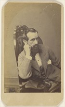 bearded man seated with right arm on chair arm, with hand to cheek; Broadbent & Company; 1865 - 1870; Albumen silver print