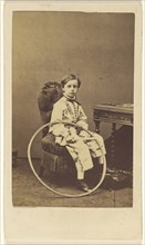 little boy seated, holding a large hoop; Désiré Durand, French, active 1860s, 1865 - 1870; Albumen silver print