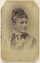 woman with her hair in a bun, crucifix around her neck, printed in vignette-style; J.B. Scholl, American, active Chicago