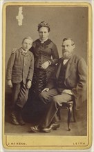 Portrait of an  family: mother and son standing, bearded father seated; John McKean, Scottish, active Leith, Scotland 1880s