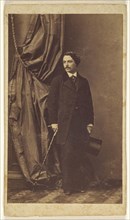 man with moustache standing, holding a top hat in one hand and a cane in the other; Disdéri & Cie; 1862 - 1866; Albumen silver
