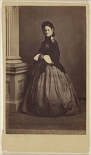 woman wearing a bonnet, standing; French; 1862 - 1864; Albumen silver print