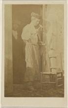 man wearing a round cap, using a hammer; 1870-1875; Albumen silver print