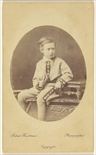 boy holding a ball, seated on an ornately carved table; Robert Faulkner, British, active 1860s - 1880s, 1865-1875; Albumen
