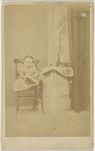 little girl seated with a book in her lap; 1865-1870; Albumen silver print