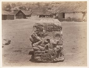 Carved block, with village buildings in background, Edmund Lincoln miscellaneous papers relating to the excavation of Maya ruins