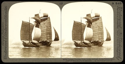 Clumsy Chinese junk under full sail on the Yellow Sea, coast of Manchuria in distance, Underwood and Underwood, Gelatin silver