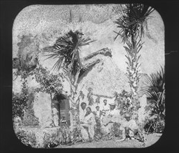 Alice Le Plongeon and a Yucatecan family in front of a thatched house, Augustus and Alice Dixon Le Plongeon papers, 1763-1937