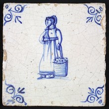 Figure tile, blue with woman with basket of apples next to her, apple-skewer, corner pattern ox-head, wall tile tile sculpture