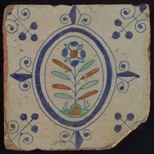 Tile, flower on spot in blue, green and orange on white, inside an oval with lilies, corner motif, wall tile tile sculpture